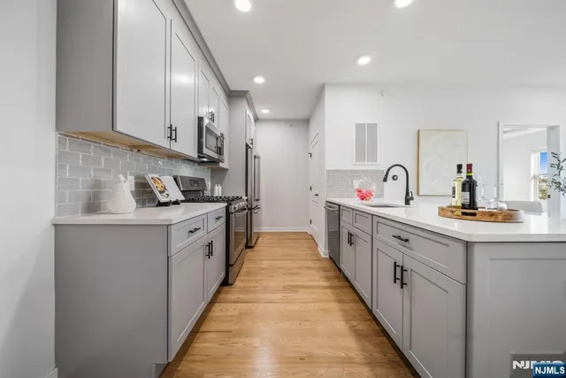 a large kitchen with stainless steel appliances lots of counter space and a sink
