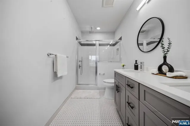 a spacious bathroom with a granite countertop sink a toilet and a mirror