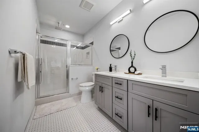 a spacious bathroom with a double vanity sink mirror and toilet