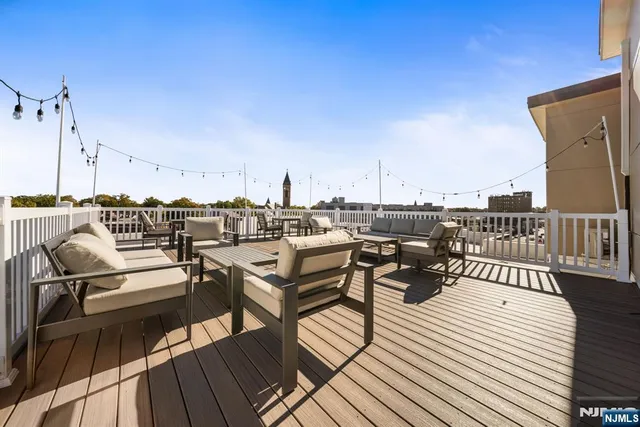 a roof deck with outdoor seating and city view