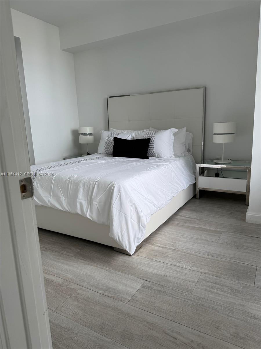 45 Southwest 9th Street, Unit 3910 Miami, FL 33130 - Photo 11 of 27 a bedroom with a bed and a wooden floor