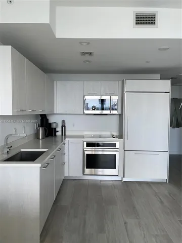 a kitchen with granite countertop a sink and a stove top oven