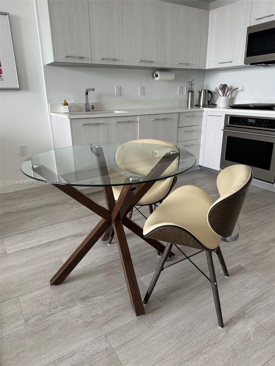 45 Southwest 9th Street, Unit 3910 Miami, FL 33130 - Photo 5 of 27 a kitchen with table chairs and white appliances
