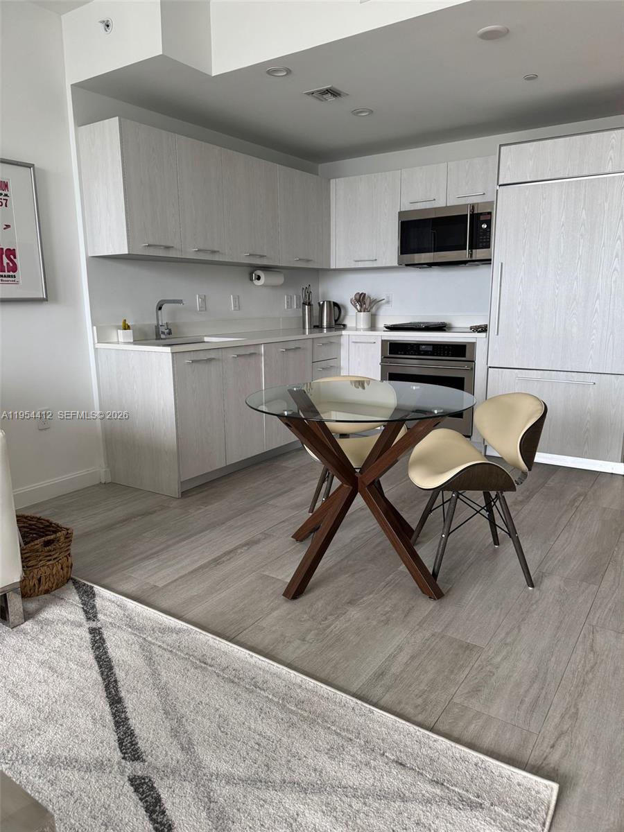 45 Southwest 9th Street, Unit 3910 Miami, FL 33130 - Photo 6 of 27 a kitchen with a sink a microwave and white appliances