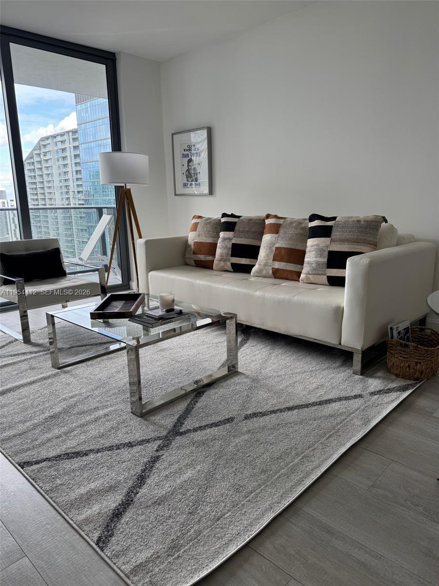 45 Southwest 9th Street, Unit 3910 Miami, FL 33130 - Photo 9 of 27 a living room with furniture gym equipment and a large window