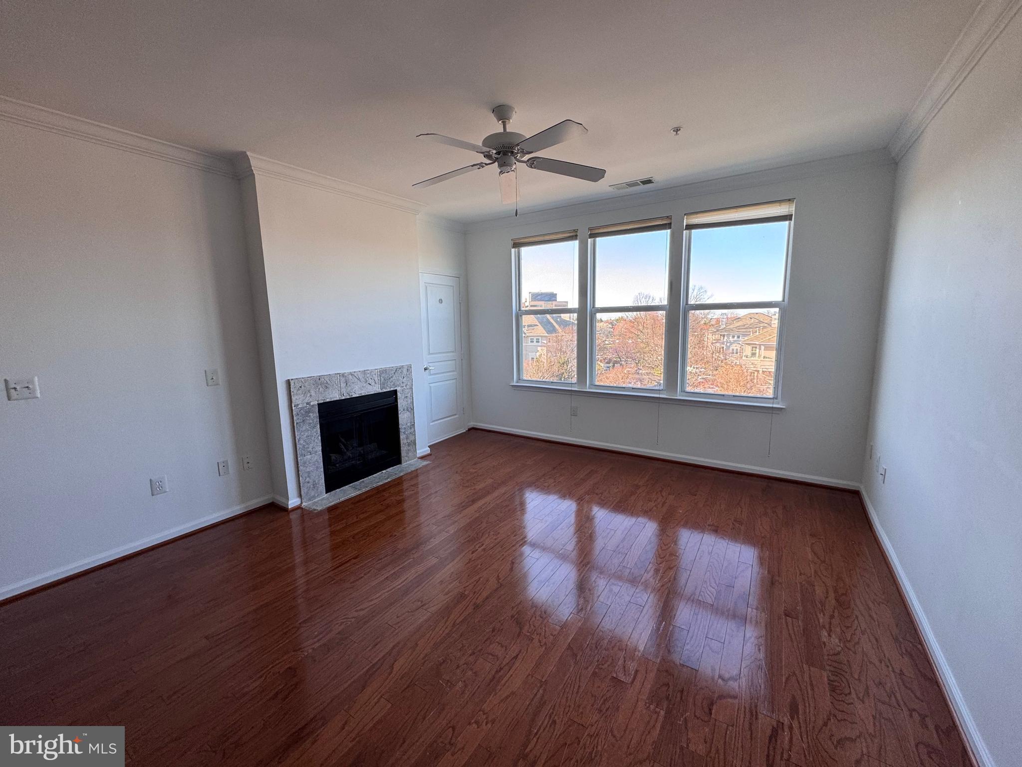 12000 Market Street, Unit 361 Reston, VA 20190 - Photo 19 of 49 an empty room with wooden floor fireplace and windows