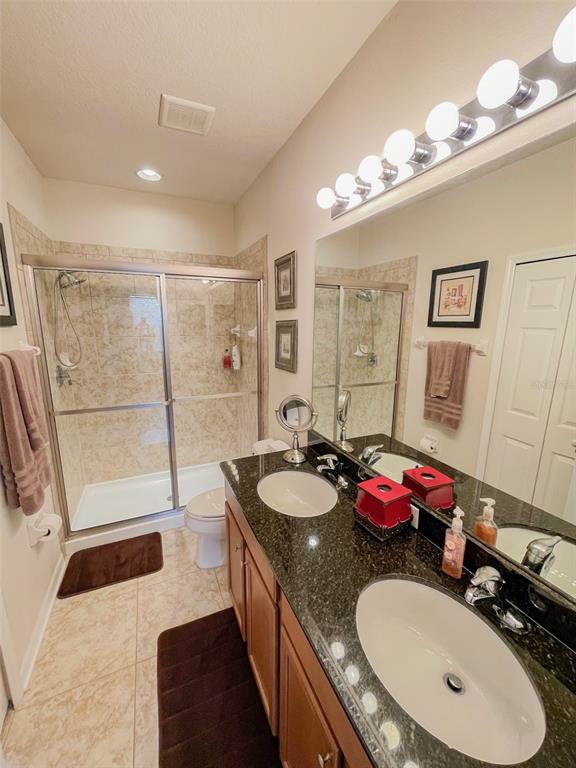 11567 84th St Circle East, Unit 105 Parrish, FL 34219 - Photo 13 of 18 a bathroom with a granite countertop sink a mirror and a shower