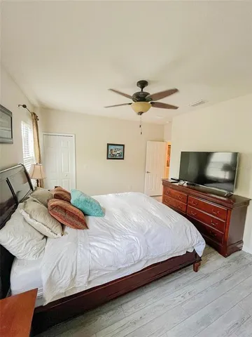 a bedroom with a bed and a ceiling fan