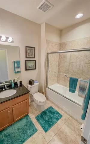 a spacious bathroom with a granite countertop sink a toilet a mirror and bathtub