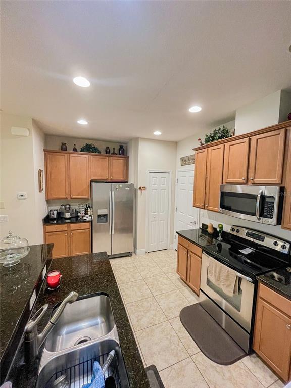 11567 84th St Circle East, Unit 105 Parrish, FL 34219 - Photo 2 of 18 a kitchen with stainless steel appliances a stove a sink a microwave a refrigerator and cabinets