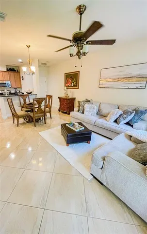 a living room with lots of white furniture and a chandelier