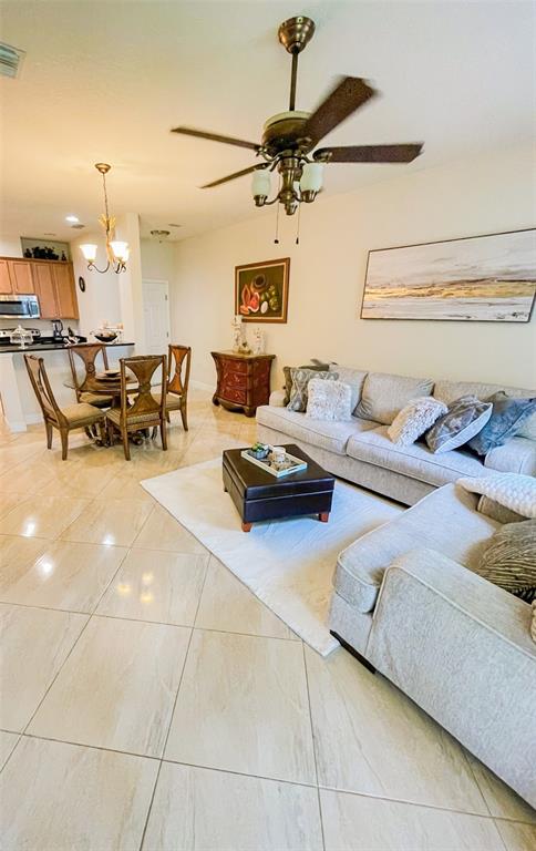 11567 84th St Circle East, Unit 105 Parrish, FL 34219 - Photo 3 of 18 a living room with lots of white furniture and a chandelier