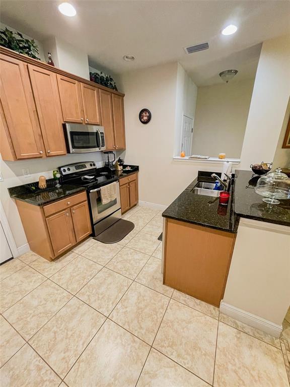 11567 84th St Circle East, Unit 105 Parrish, FL 34219 - Photo 6 of 18 a kitchen with stainless steel appliances granite countertop a sink and a stove