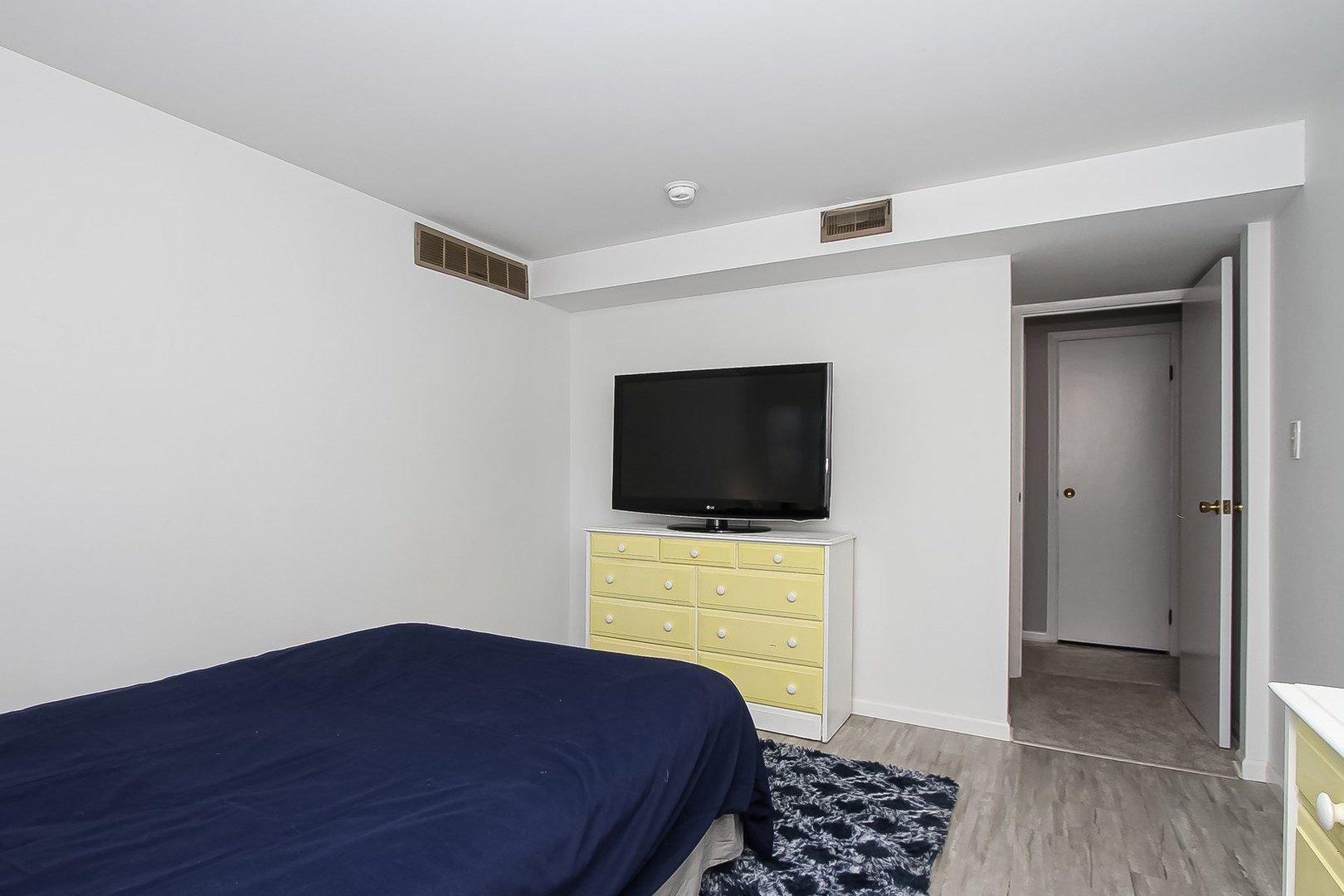 993 Bernard Drive Buffalo Grove, IL 60089 - Photo 17 of 29 a bedroom with a bed and a flat screen tv