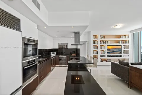 a spacious bedroom with a large bed and a chandelier