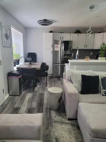 a living room with furniture a kitchen view and a appliances