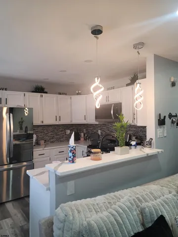 a kitchen with a sink dishwasher and a refrigerator with wooden floor