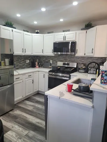 a kitchen with stainless steel appliances kitchen island granite countertop a sink stove and cabinets