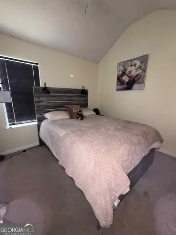 a bedroom with a bed and a night stand