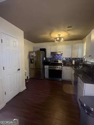 a kitchen with stainless steel appliances granite countertop a stove and a refrigerator