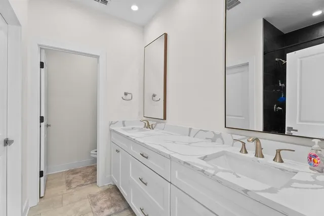 a bathroom with a double vanity sink and a mirror