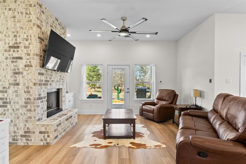 12754 Ridgeway Court Winona, TX 75792 - Photo 6 of 38 a living room with furniture a fireplace and a flat screen tv