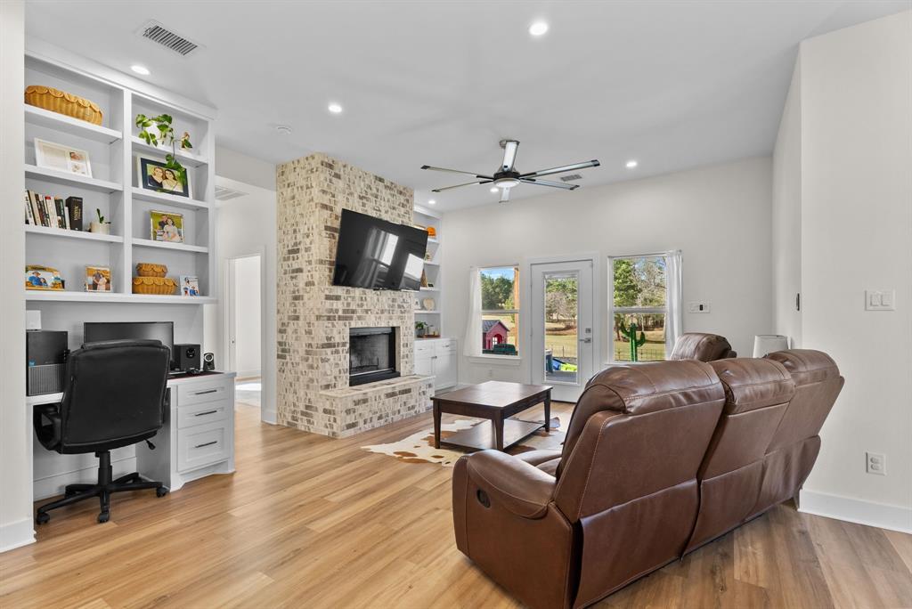 12754 Ridgeway Court Winona, TX 75792 - Photo 8 of 38 a living room with furniture a fireplace and a flat screen tv