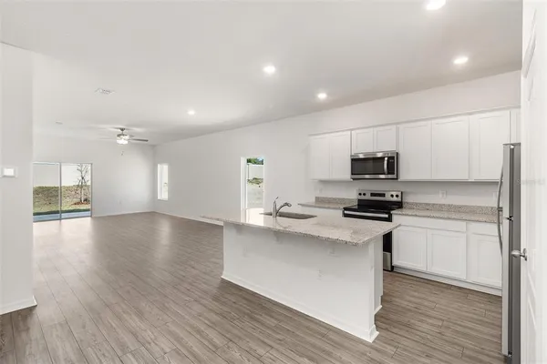 a kitchen with stainless steel appliances a white stove top oven sink and cabinets
