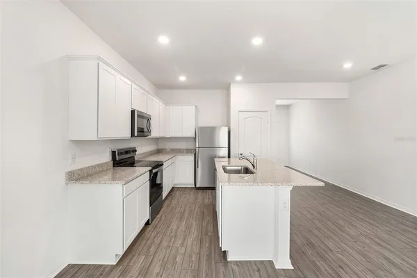 a kitchen with a sink a counter top space stainless steel appliances and cabinets