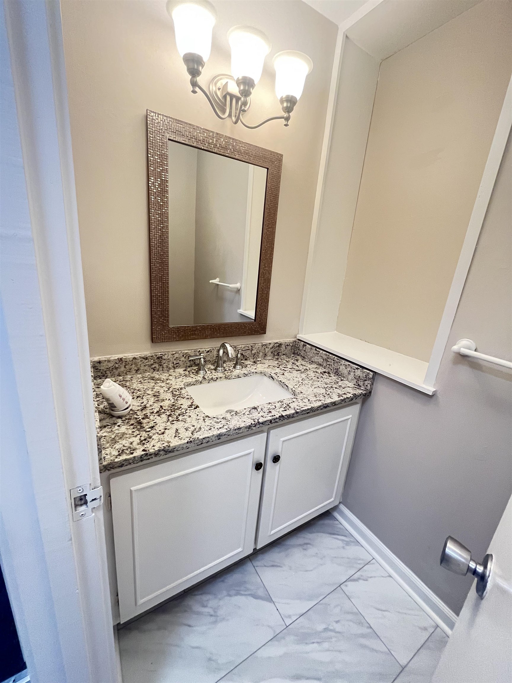 5763 Barfield Road, Unit 5763 Memphis, TN 38120 - Photo 11 of 21 a bathroom with a granite countertop sink and a mirror