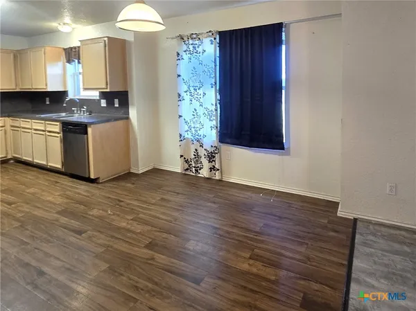 a kitchen with stainless steel appliances granite countertop a hardwood and cabinets