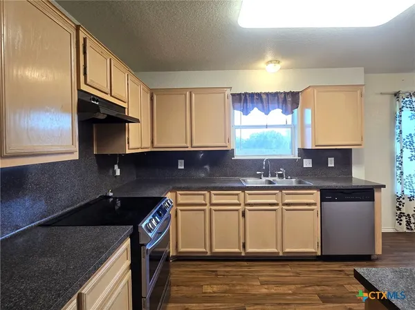 a kitchen with stainless steel appliances granite countertop a sink stove and cabinets