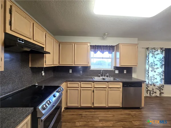 a kitchen that has a sink and a stove