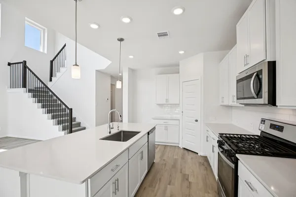 a view of a big yard in front of a brick house with a big yard and large trees