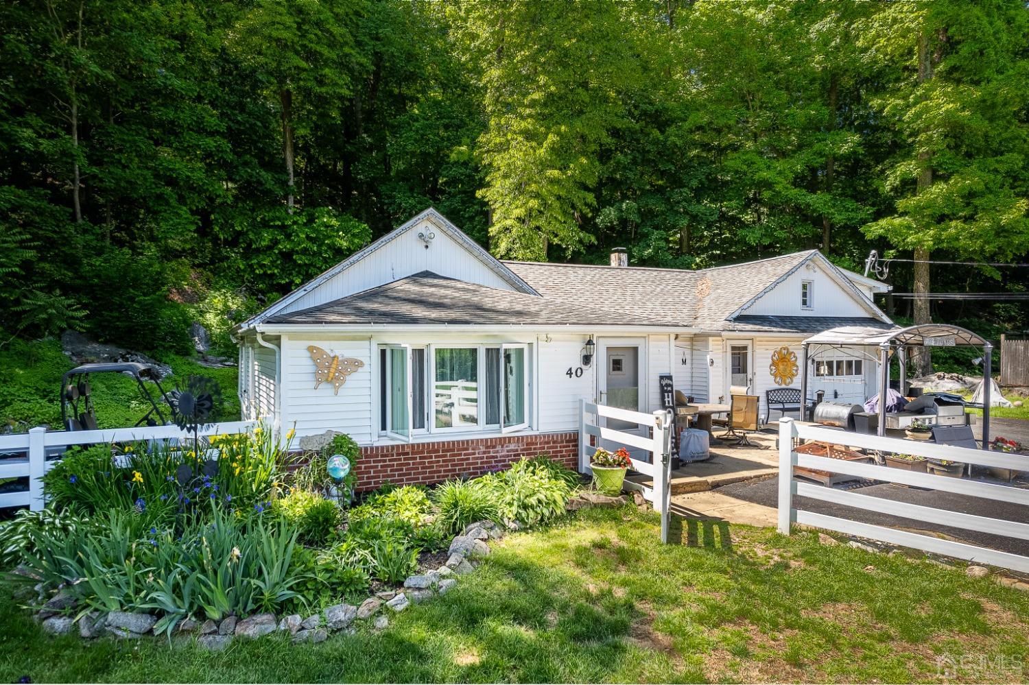 a white house with a large pool and lawn chairs under an umbrella