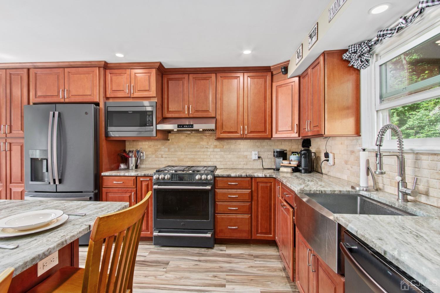 40 Emmans Road Ledgewood, NJ 07852 - Photo 9 of 24 a kitchen with stainless steel appliances granite countertop a stove top oven a sink dishwasher a refrigerator and a dining table with wooden floor