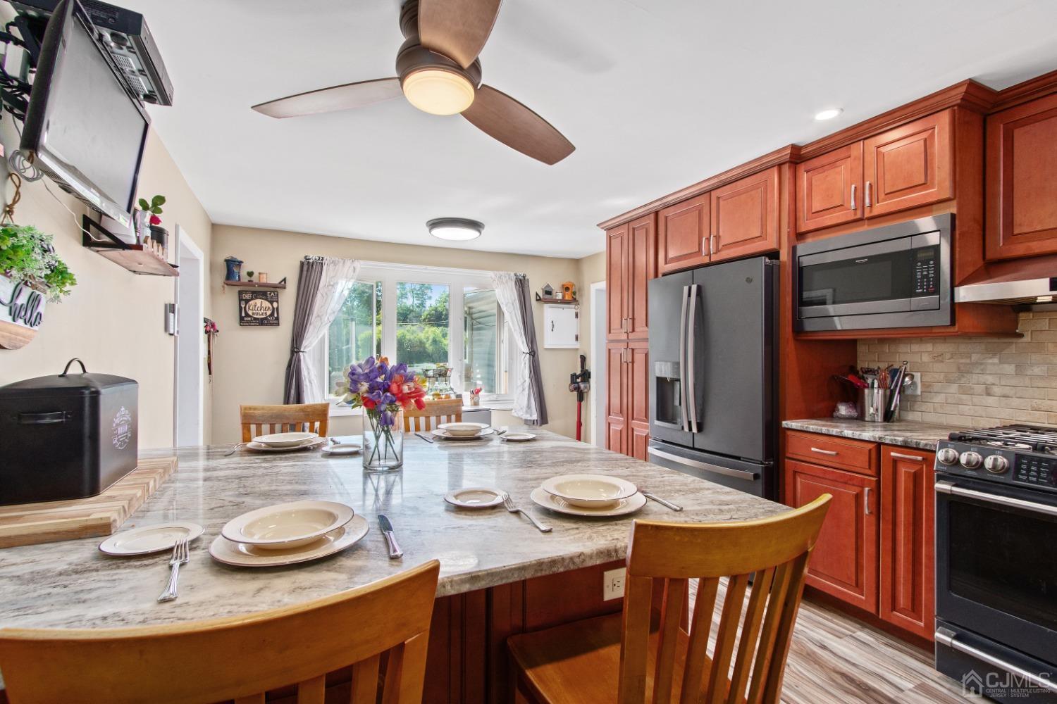 40 Emmans Road Ledgewood, NJ 07852 - Photo 10 of 24 a kitchen with stainless steel appliances granite countertop a stove a refrigerator a oven with a dining table and chairs