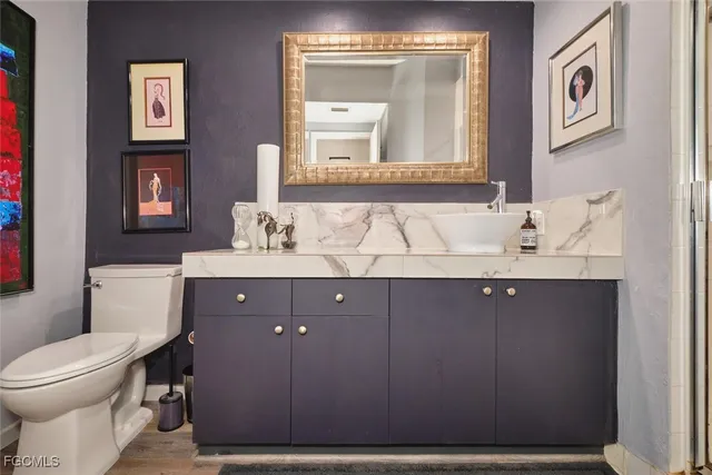 a bathroom with a sink vanity mirror and toilet