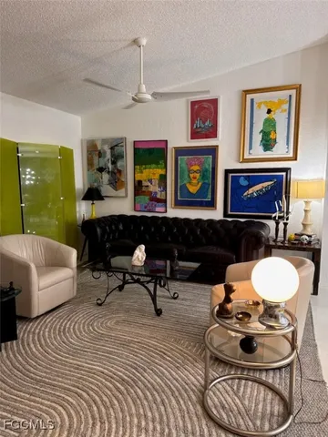 a living room with furniture and a wall painting