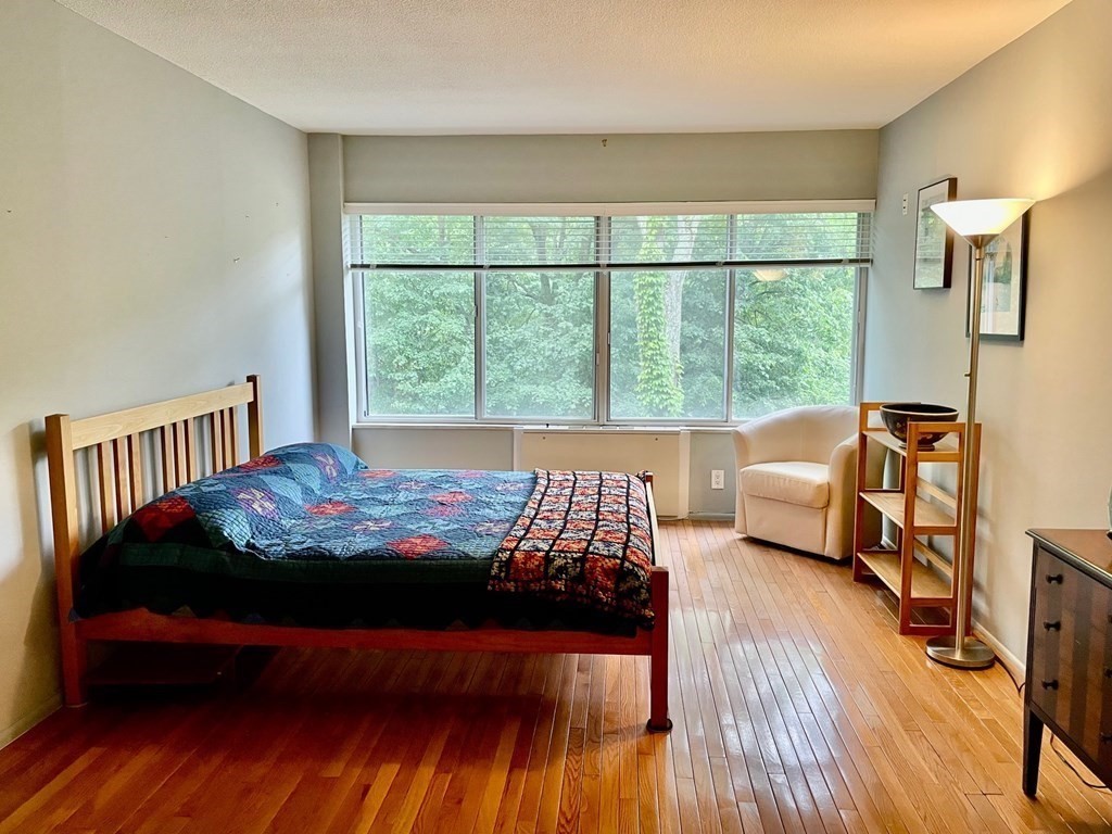 22 Chestnut Place, Unit 316 Brookline, MA 02445 - Photo 13 of 19 a bedroom with a bed and wooden floor