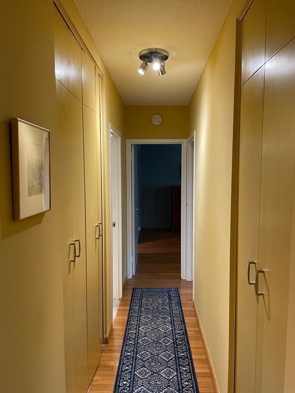 22 Chestnut Place, Unit 316 Brookline, MA 02445 - Photo 10 of 19 a view of a hallway with wooden floor and a bathroom