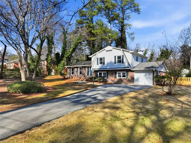a view of a house with a big yard and large trees