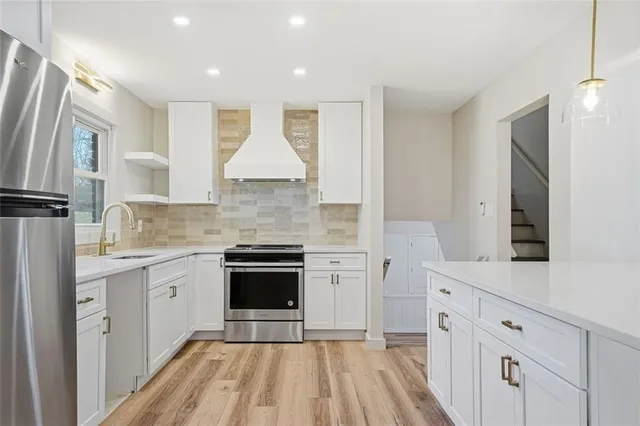 a kitchen with white cabinets and appliances