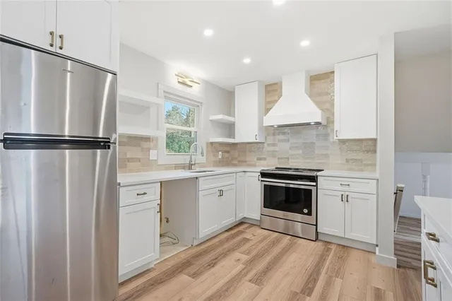 a kitchen with a refrigerator a sink and cabinets