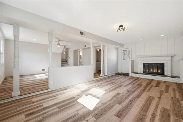 a view of empty room with wooden floor and fireplace
