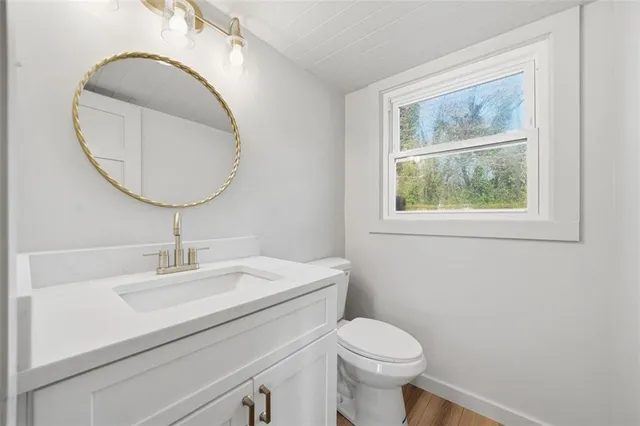 a bathroom with a sink a toilet and a mirror