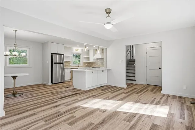 a view of a kitchen with wooden floor electronic appliances and windows