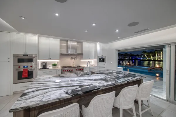 a living room with furniture kitchen view and a large window