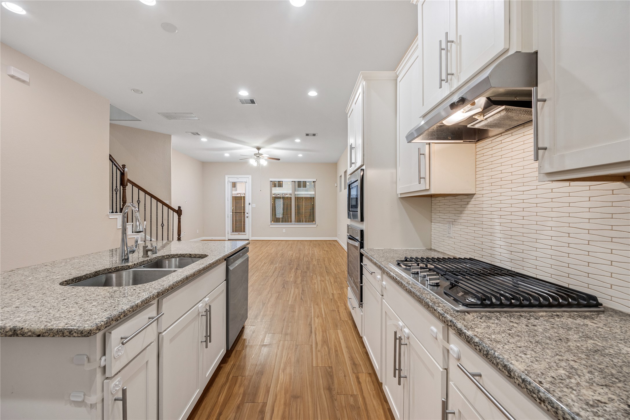 10408 Quiet Courtyard Road Houston, TX 77043 - Photo 6 of 24 White kitchen featuring built-in appliances and a clean, functional layout.