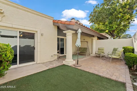 a backyard of a house with table and chairs